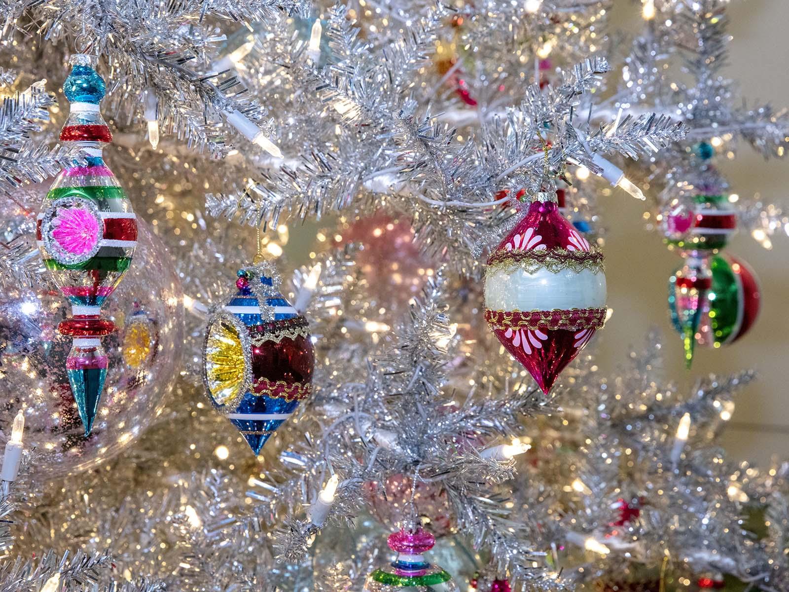 Ornaments on a silver Christmas tree.